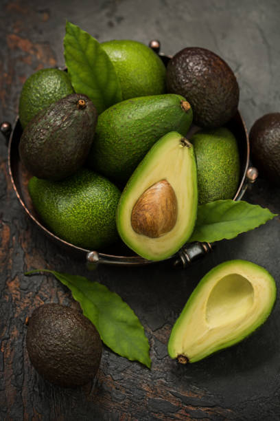 avocats frais dans un plat vintage sur la table. - avocat légume photos et images de collection