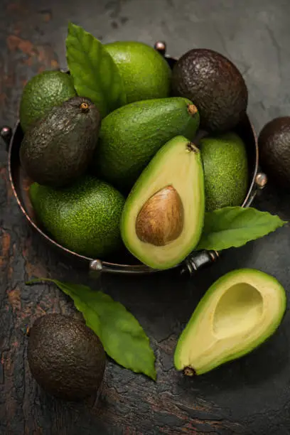 Fresh avocados in a vintage dish on the table.