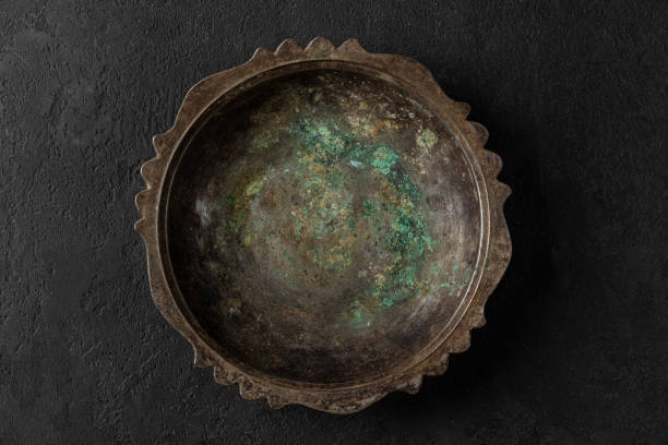 istock Empty vintage metal copper plate or bowl with blue rust on black stone background. low key. top view 1322141325