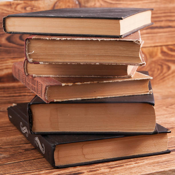 istock Old shabby books lying on a wooden surface 1322142833