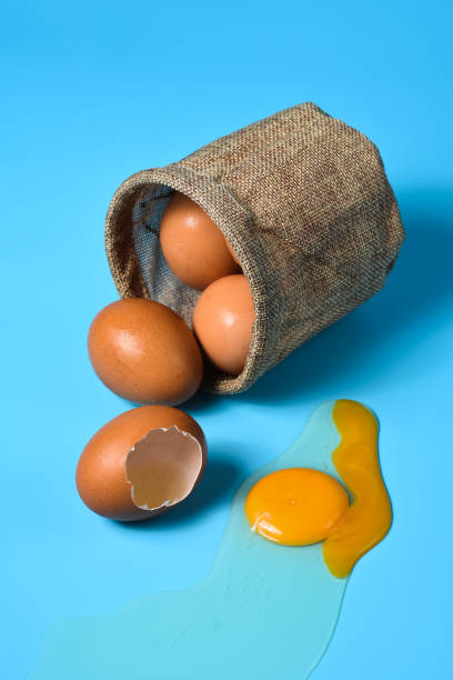 istock Fresh eggs in a sack bag on blue background. 1322143048