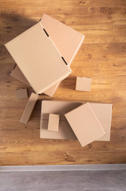 istock Stack of cardboard box at floor laminate background. Empty box case top view. Moving or relocation concept 1322143361