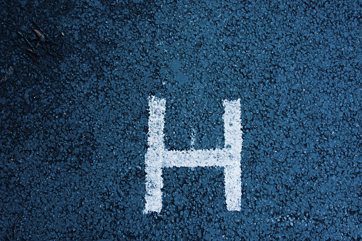 letter H painted on tarmac of a parking bay