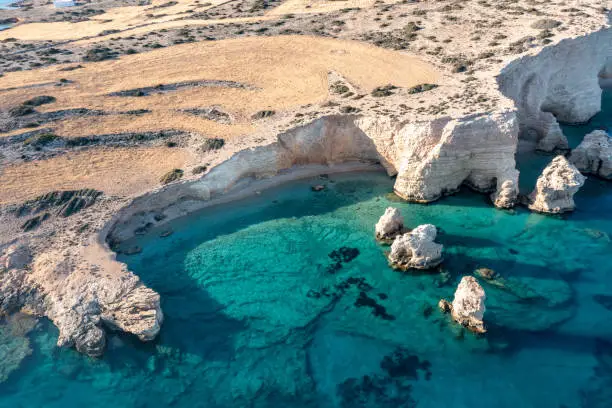 Greece, small Cyclades islands. Koufonisi secluded beach aerial drone view. Rocky cliffs over clear turquise sea water. Sunny day, tranquil summer holidays destination