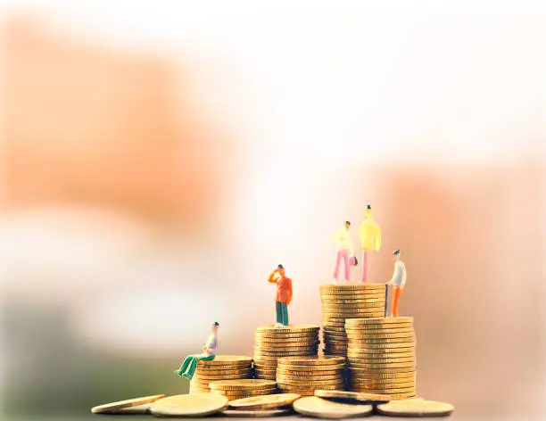 Photo of Concept of retirement planning, miniature people - Old couple figure standing on top of gold coin stack