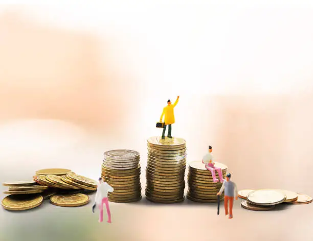 Photo of Miniature people standing businessman on top of stacks coins, small businessman figure - Concept of retirement planning
