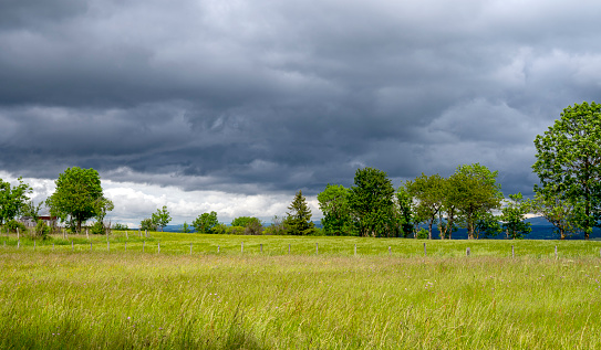 Landscape of the Haute-Loire department around Yssingeaux with a threatening sky and stormy clouds