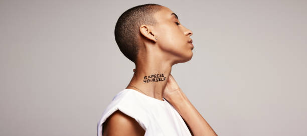 istock Shaved head woman with express yourself written on her neck 1322155141