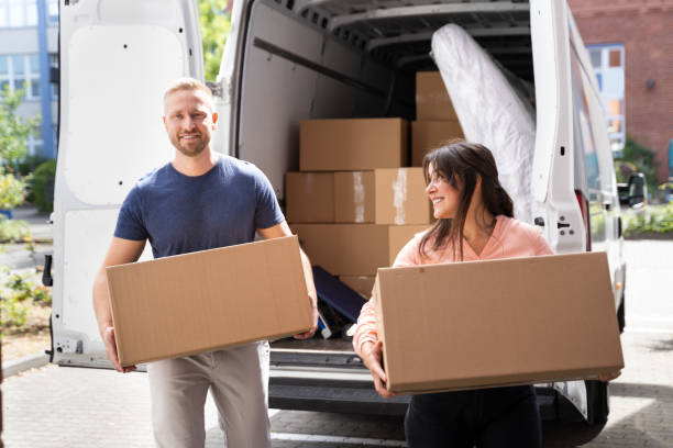 istock Couple Moving Boxes From Van Or Truck 1322156342