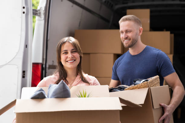istock Couple Moving Boxes From Van Or Truck 1322156375