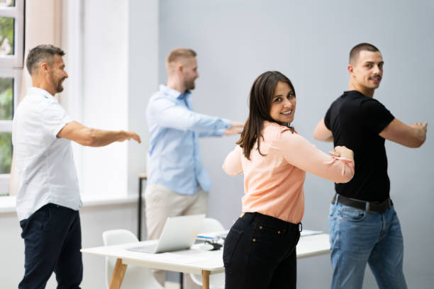 istock Group Of Happy Young Businesspeople Doing Stretching Exercise 1322156992