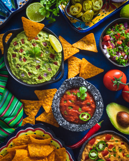 istock Mexican dip sauces guacamole, cheedar dip, tomato salsa and pico de gallo with Nacho chips 1322160101