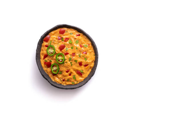 cheedar cheese dip sauce with Nacho chips with tomato and chili isolated on white