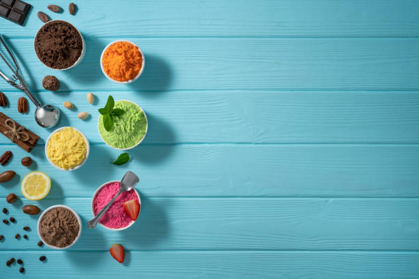 istock Assorted ice cream cups and waffle cones colorful different flavor on blue wood 1322160258