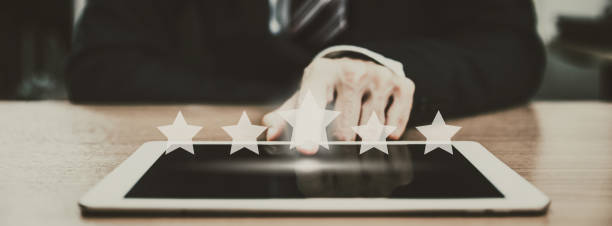 istock Business man using tablet with graphic of customer service star rate in mobile application 1322160916