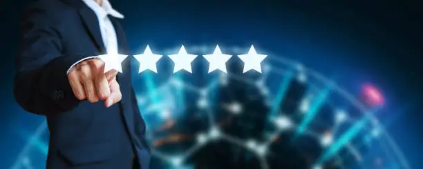 Business man pointing five star icon to give rate of company customer service on blur city night background