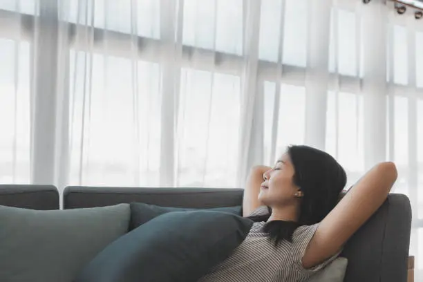 Happy lifestyle asian woman relax and sleep on sofa in living room at home