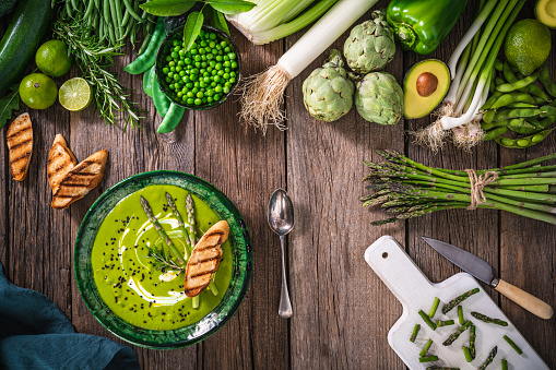 Asparagus soup with Vegan raw vegetables on rustic wood table board with copy space background