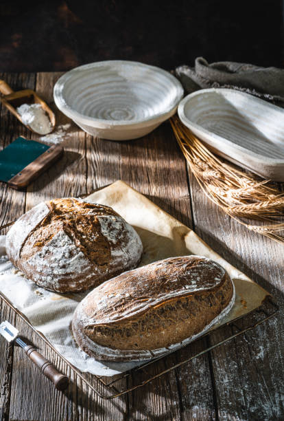 istock Sourdough bread loaf and Banneton basket in bakery on wooden rustic table 1322161338