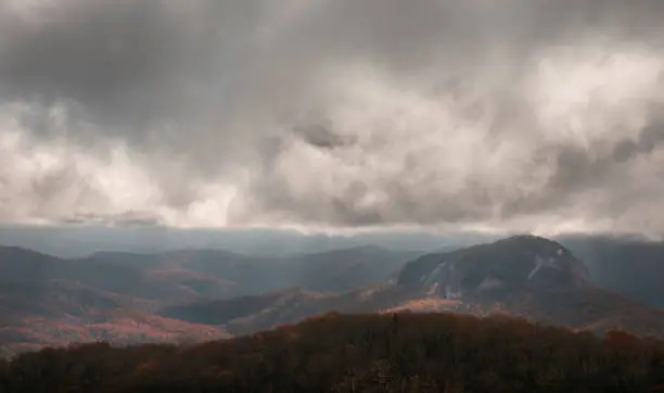 Grey clouds sit atop Looking Glass Rock during the autumn in the Blue Ridge Mountains and Pisgah National Forest