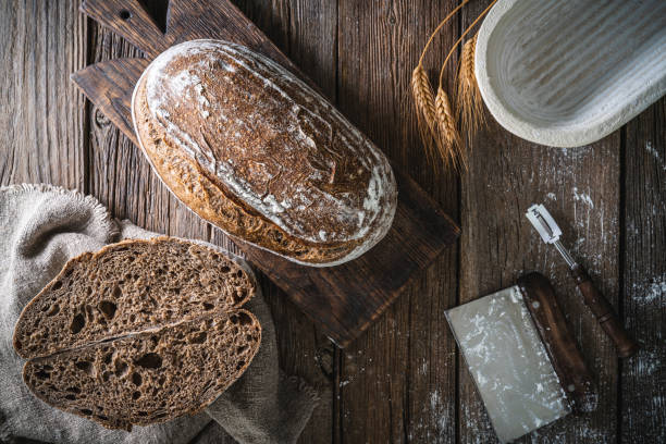 istock Sourdough bread loaf and Banneton basket in bakery on wooden rustic table 1322161406