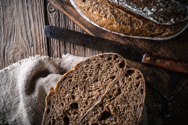 istock Sourdough bread loaf and Banneton basket in bakery on wooden rustic table 1322161431