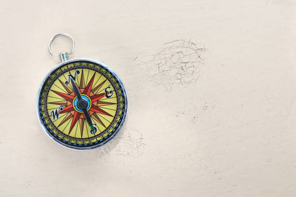 istock classic navigation compass on yellow vintage background with scratches and cracks in paint as symbol of tourism with compass, travel with compass and outdoor activities with compass 1322162044
