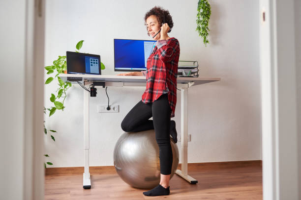 istock Woman telecommuting at an adjustable standing desk 1322162170
