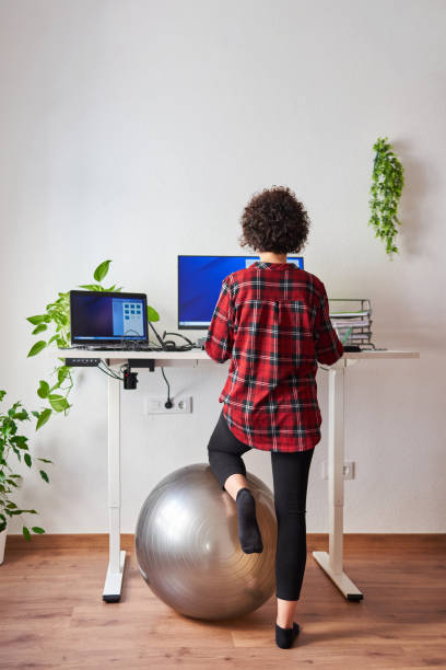 istock Woman telecommuting at an adjustable standing desk 1322162177