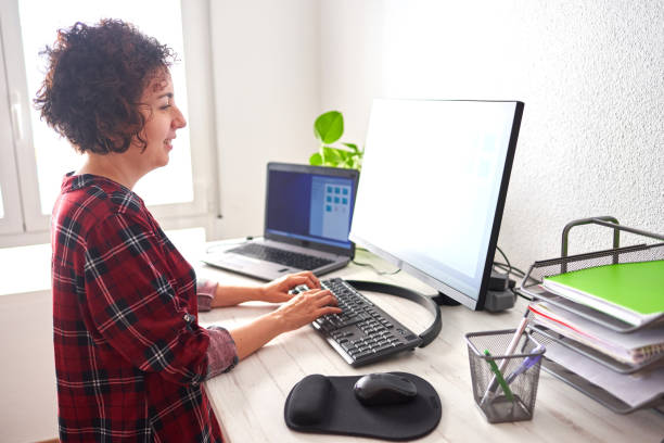 Woman typing on computer at adjustable standing desk