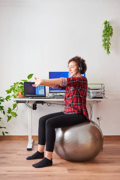 istock Woman stretches while working out sitting on a fitball 1322162449