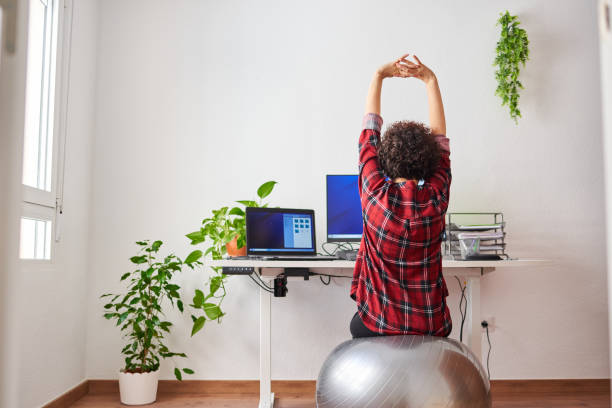 istock Woman stretches while working out sitting on a fitball 1322162496
