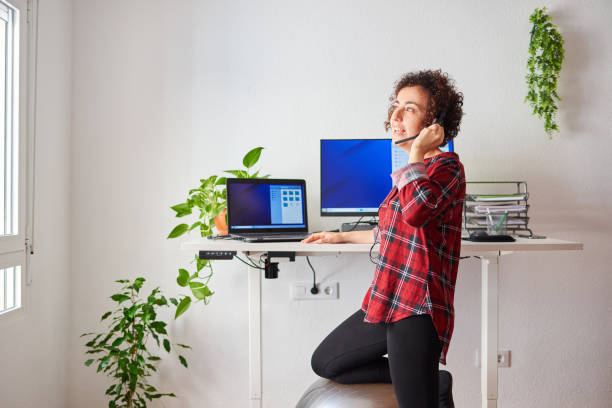 istock Woman telecommuting at an adjustable standing desk 1322162498