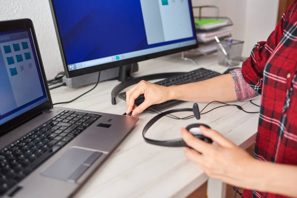 istock Unrecognizable woman connecting a headset to a laptop 1322163213