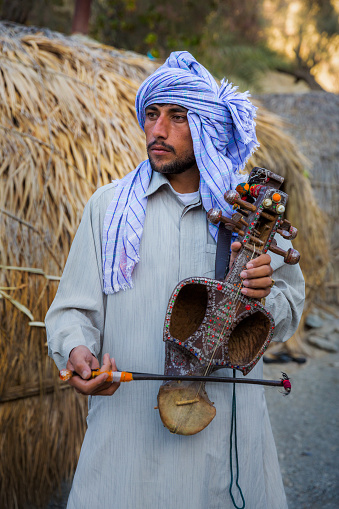 NIKSHAHR COUNTY, IRAN - FEBRUARY 11, 2012. The Baluchi tribe is one of the oldest Iranian tribes whose music is influenced by Indian melodies because of being close to India. Of musical instruments in Baluchestan one may refer to Tanburak (small guitar), Setar (three stringed guitar), Qalam, a flute with five or seven sections, the pitcher, the oboe, ordinary and small kettledrum, the tambourine and roebuck or Hijdah (eighteen) Tar.