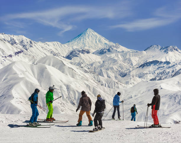 het uitzicht op skiërs en de berg damavand vanuit het skigebied darbandsar in teheran, iran. - nouri stockfoto's en -beelden