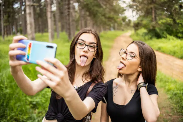 LGBT lesbian couple spending time in nature, using a beautiful day for a walk together and moments of happiness.