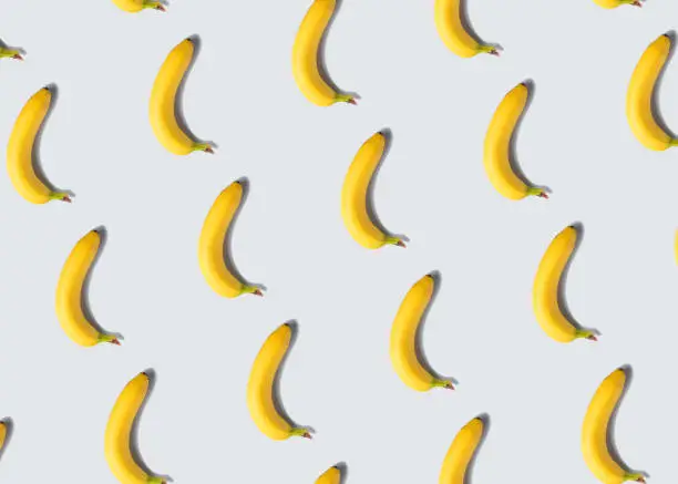Single banana fruit pattern on light gray minimal background