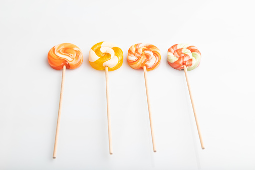 Four lollipop candies isolated on white background. close up, side view.