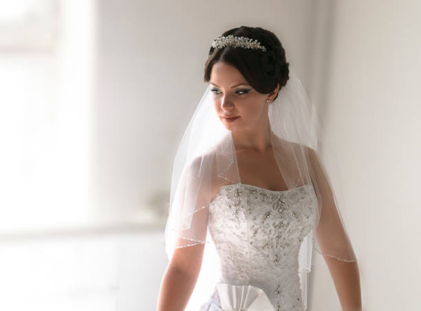 istock The bride stands by the window during the day. 1322166028
