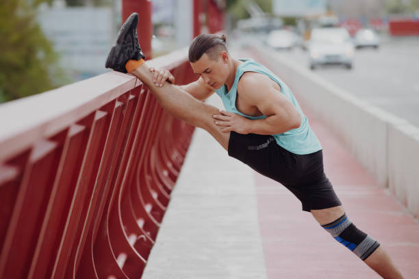 istock Man stretches leg before running on a bridge 1322168625