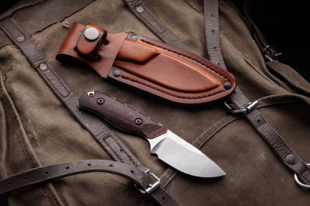 istock A hunting knife with a wooden handle and a leather case on a khaki canvas backpack. Weapons for self-defense and survival. 1322171600