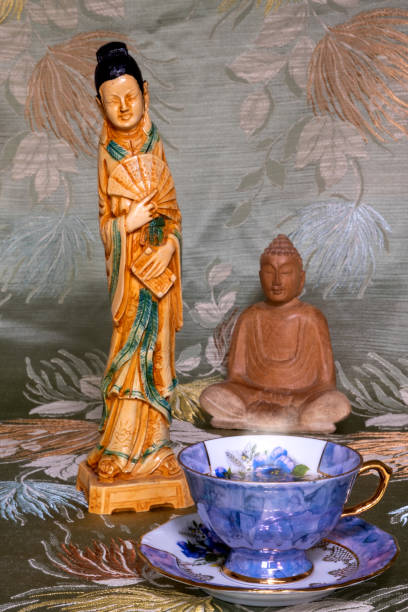 natura morta di tazza da tè, buddha di legno e scultura asiatica di donna - asian cuisine blue japanese culture still life foto e immagini stock