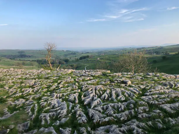 Malham cove, overlooking the Yorkshire Dales in bright sunlight, sunlit limestone pavement at the summit of Malham Cove, Malham, North Yorkshire, Yorkshire Dales, England, United Kingdom