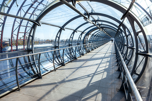 Pedestrian bridge from steel and glass for crossing over the railway tracks in Samara, Russia