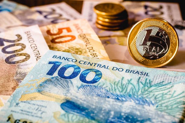 在這張照片插圖中，顯示一百二十雷亞爾鈔票和一枚雷亞爾硬幣突出顯示。皇馬是巴西目前的貨幣 - 銀紙 圖片 個照片及圖片檔