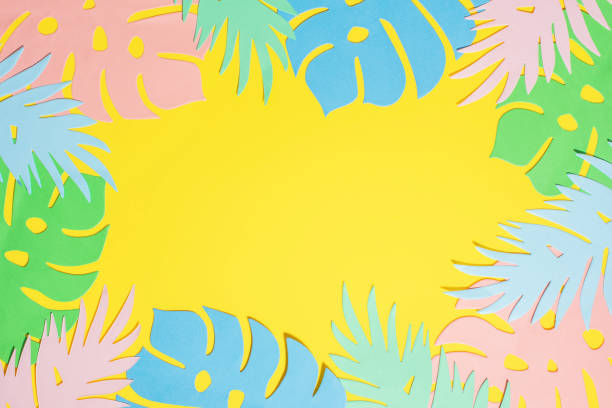 istock Paper cut monstera and palm leaves frame on yellow background with copy space. 1322176502