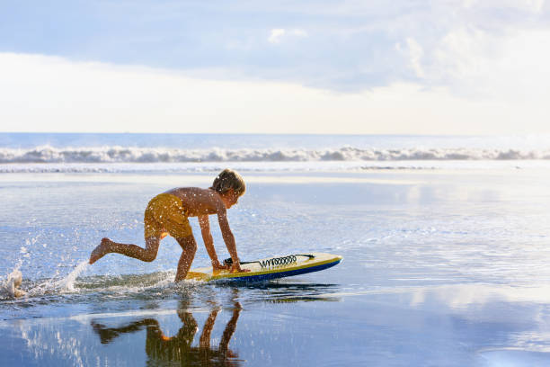 istock Boy with bodyboard have fun on sea beach 1322177713