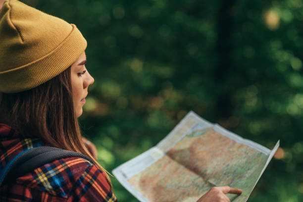istock A hiker woman using map for orientation while walking in the forest 1322179973