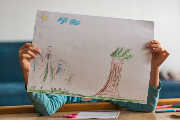 istock Unrecognizable child holding her drawing on a paper 1322181583